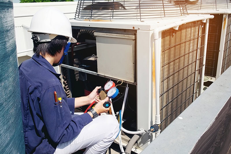 A technician working on an air conditioning unit.